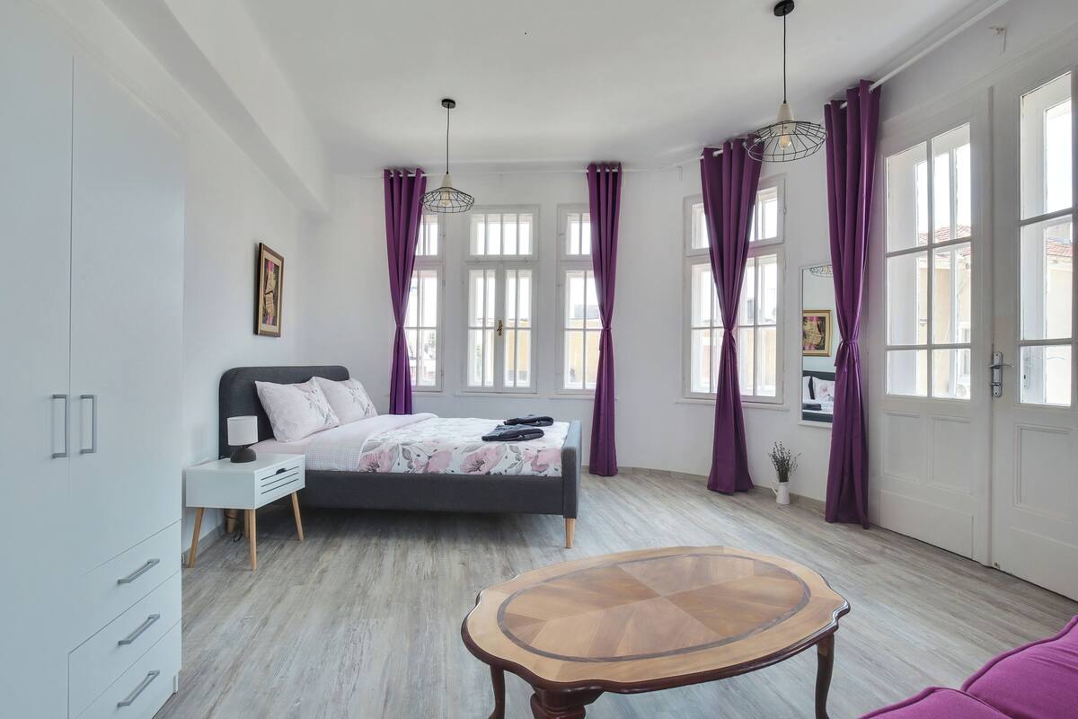 A bedroom with a bed, bedside table, and a small table.