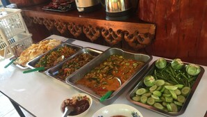 A buffet table with various dishes and condiments.