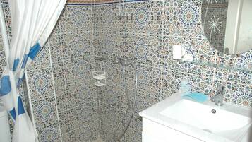 Ein Badezimmer mit Dusche, Waschbecken und dekorativen Fliesenwänden.