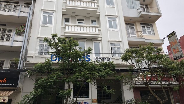 Un edificio de varios pisos con un cartel que dice 'Dreams Hotel' y 'Khách sạn GIÀC Mô'.