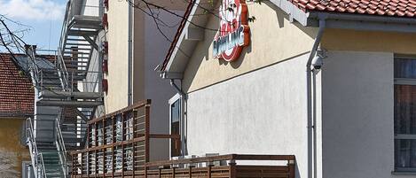 Un edificio con techo de tejas rojas, una escalera visible y un letrero que dice "RAD BOWLING".