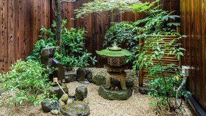 A Zen garden with a wooden fence, rocks, and a small stone lantern. - Kyoisuke (Kyoto)