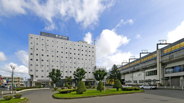 Un hotel de diseño moderno, con un edificio amplio de varios pisos y techo plano.
