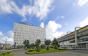 A hotel with a modern design, featuring a large building with multiple floors and a flat roof.