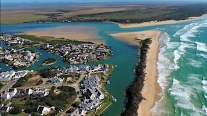 An aerial view of a coastal area with residential buildings, a beach, and a river. - Captain's Reach St. Francis Bay (Saint Francis Bay)