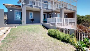 A two-story house with a balcony, a lawn, and a wooden fence. - Captain's Reach St. Francis Bay (Saint Francis Bay)