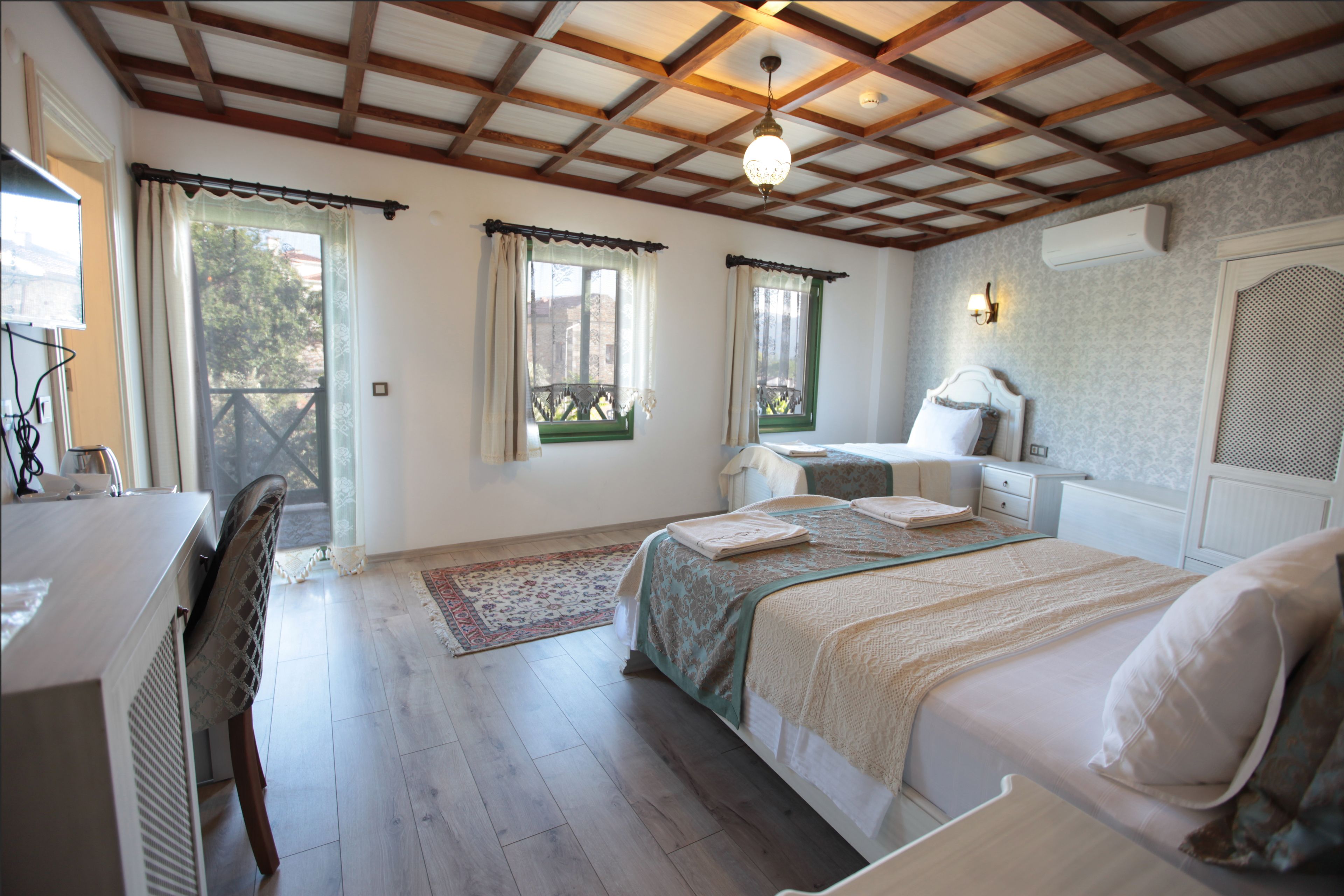Un dormitorio con cama, mesitas de noche, un escritorio y una silla.