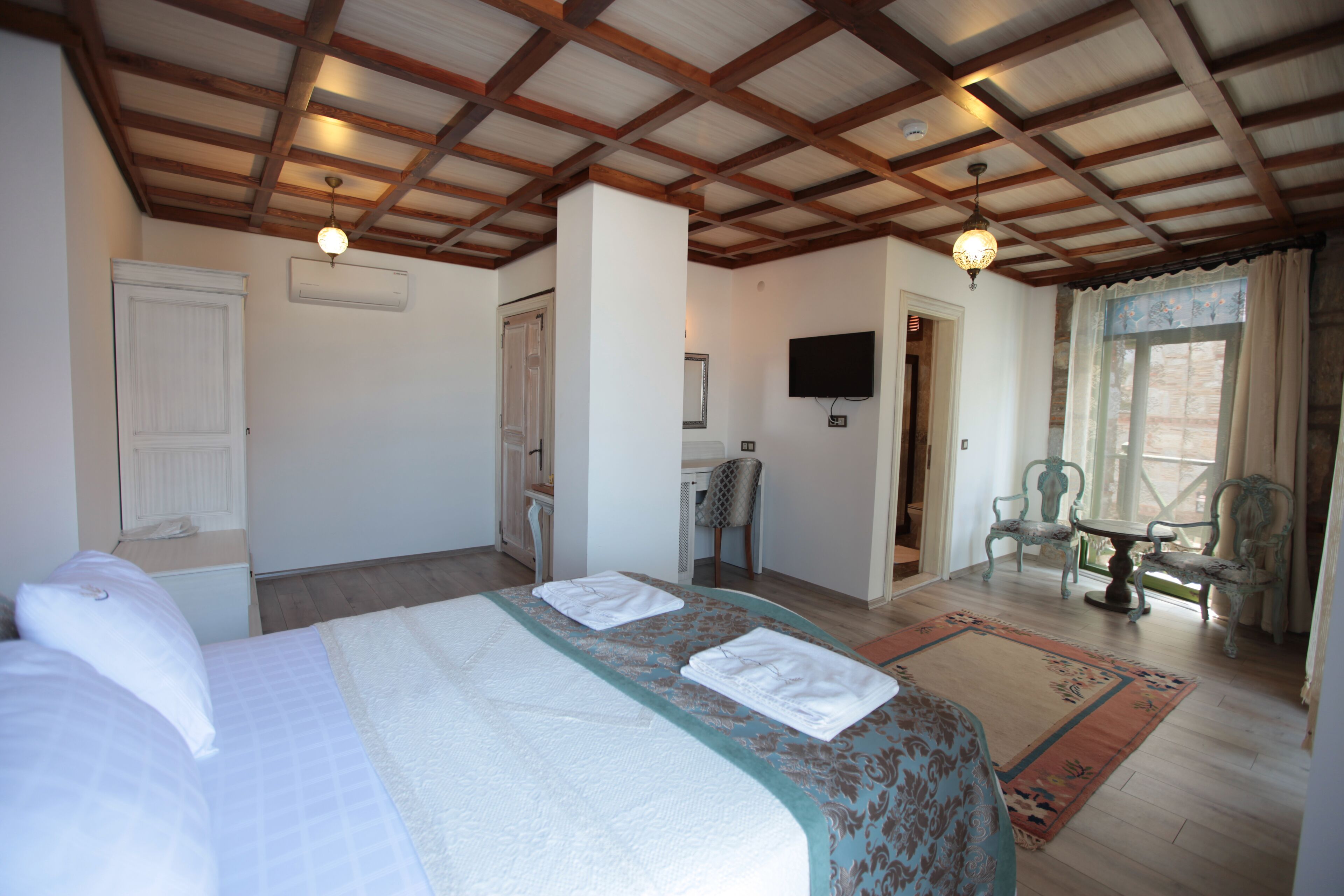 Une chambre d’hôtel avec un lit, un bureau, une chaise et un téléviseur.