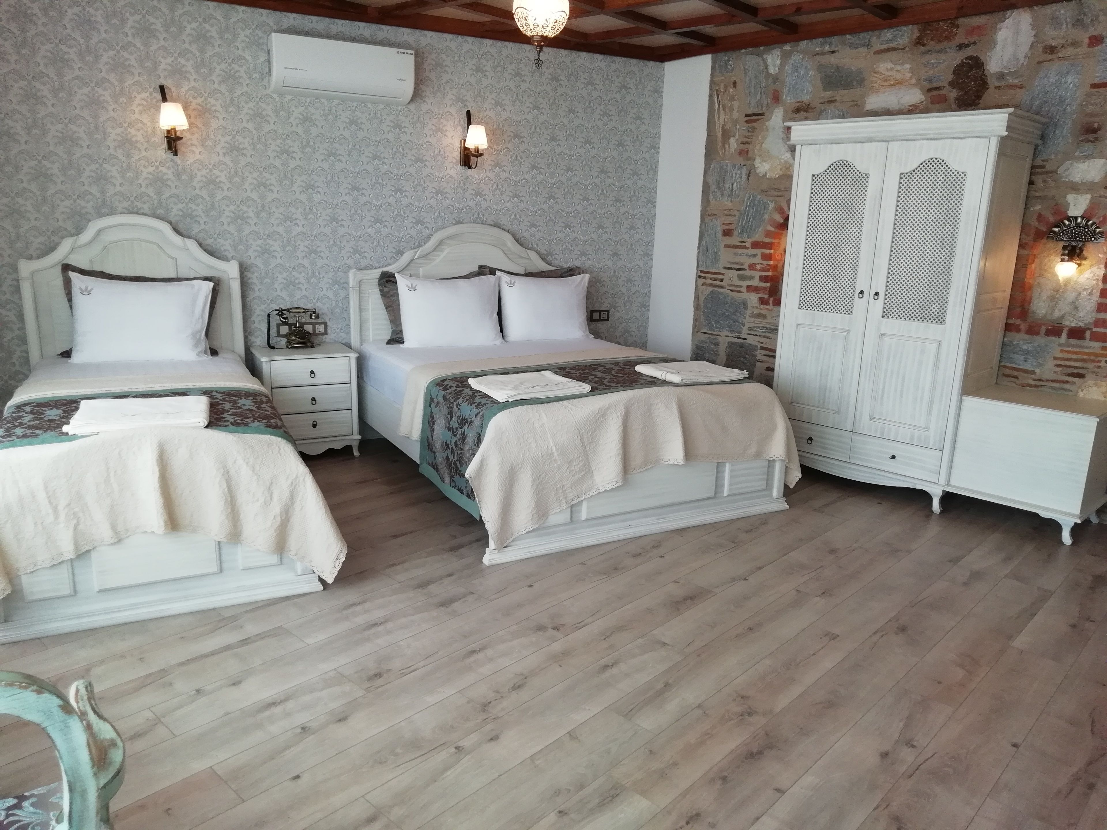 Une chambre avec deux lits, une armoire et une table de chevet.