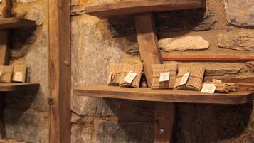 Holzregale mit verpackten Waren an einer Steinwand.