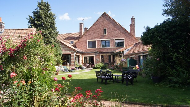 A large brick house with a well-maintained lawn, outdoor seating area, and garden. - Le Paddock du Val de Lys (Blessy)