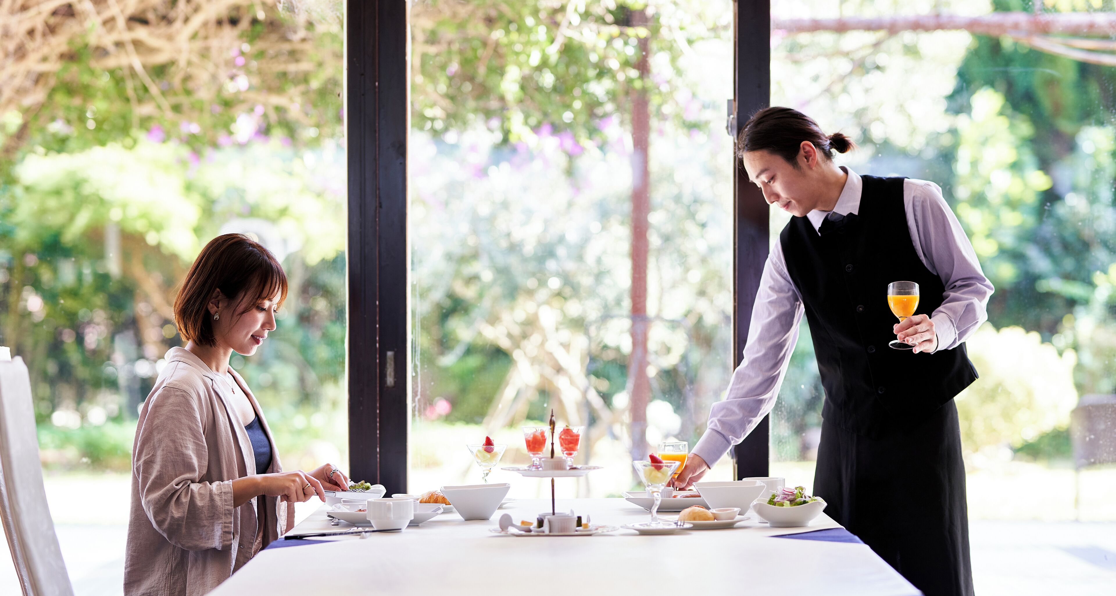 A dining table with various dishes and a person serving food.