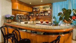A bar area with a curved counter, bar stools, and a variety of bottles and glasses. - Hotel Alsen (Rimini)