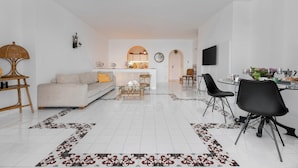 A modern living room with a sofa, coffee table, and dining area. - Villa del Sole (Massa Lubrense)