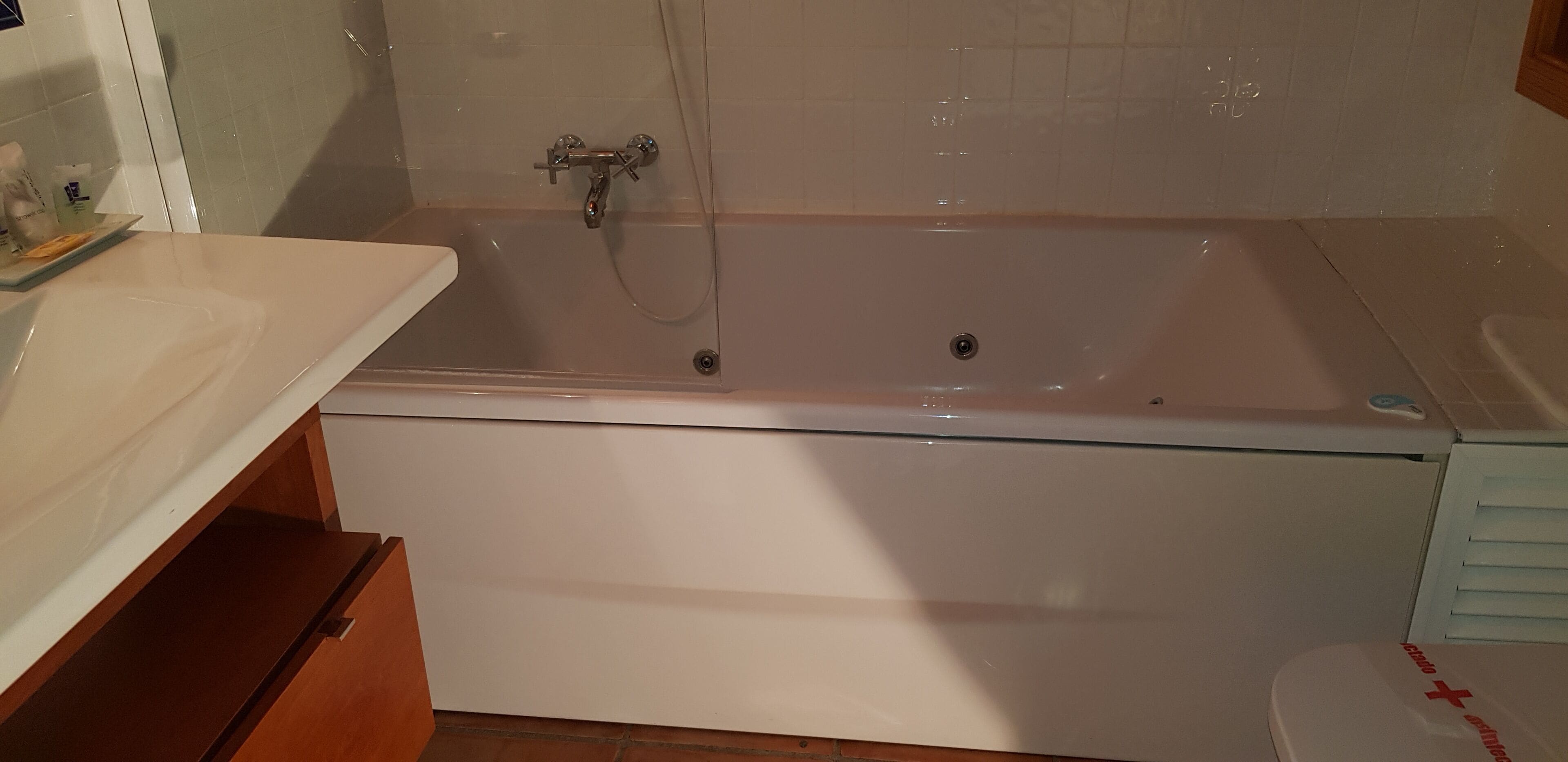 Un baño con una bañera grande, un lavabo blanco y un inodoro.