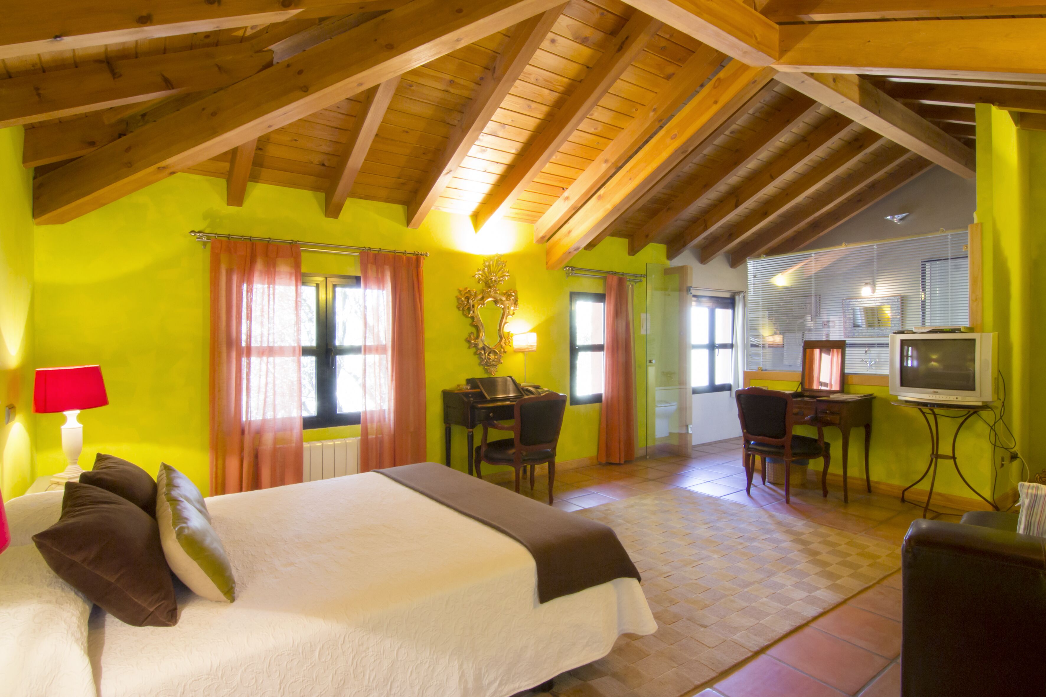 Una habitación de hotel con cama, escritorio y televisor.