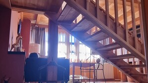 A wooden staircase with a high ceiling and a view of the interior space below. - Hotel Sara De Ur (La Cabrera)