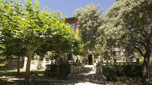 A building with a stone facade, a set of stairs leading to the entrance, and a bicycle parked under a tree. - Hotel Sara De Ur (La Cabrera)