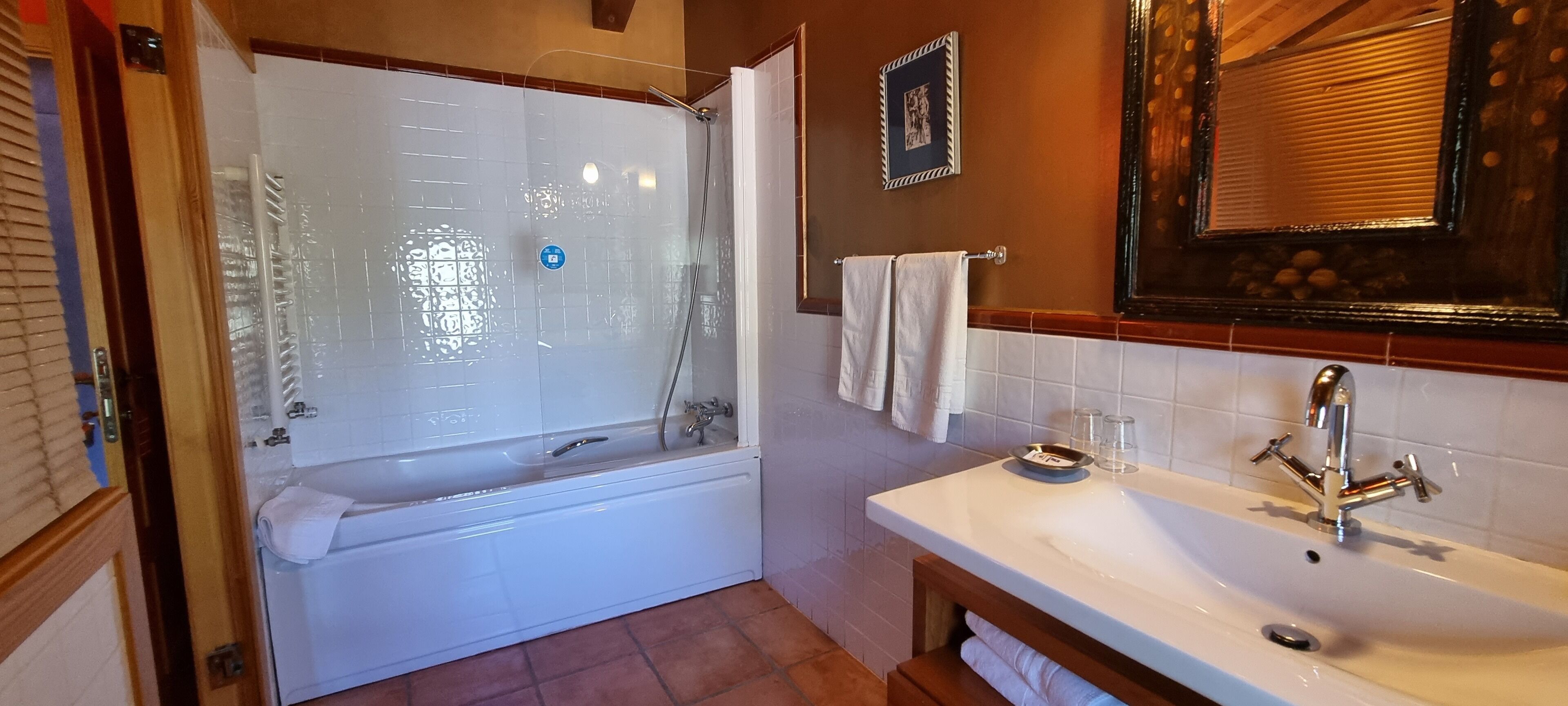 Un baño con bañera, lavabo y espejo.