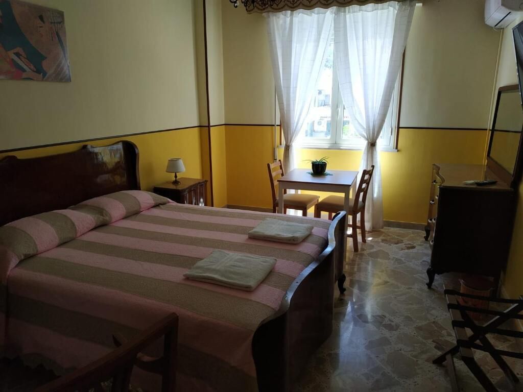 Ein Zimmer mit einem Bett, einem kleinen Tisch und einem Stuhl.