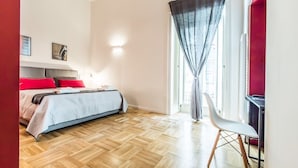Een slaapkamer met een bed, een stoel en een raam met gordijnen.