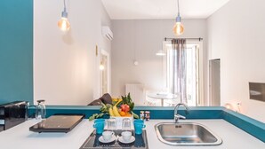 Een moderne keuken met een centraal kookeiland, een spoelbak en hangende hanglampen.