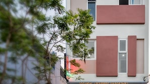 A multi-story hotel with a modern facade, featuring a reception area with a desk and chairs, and a visible staircase leading to the entrance. - Anh Villa Hotel (Da Nang)