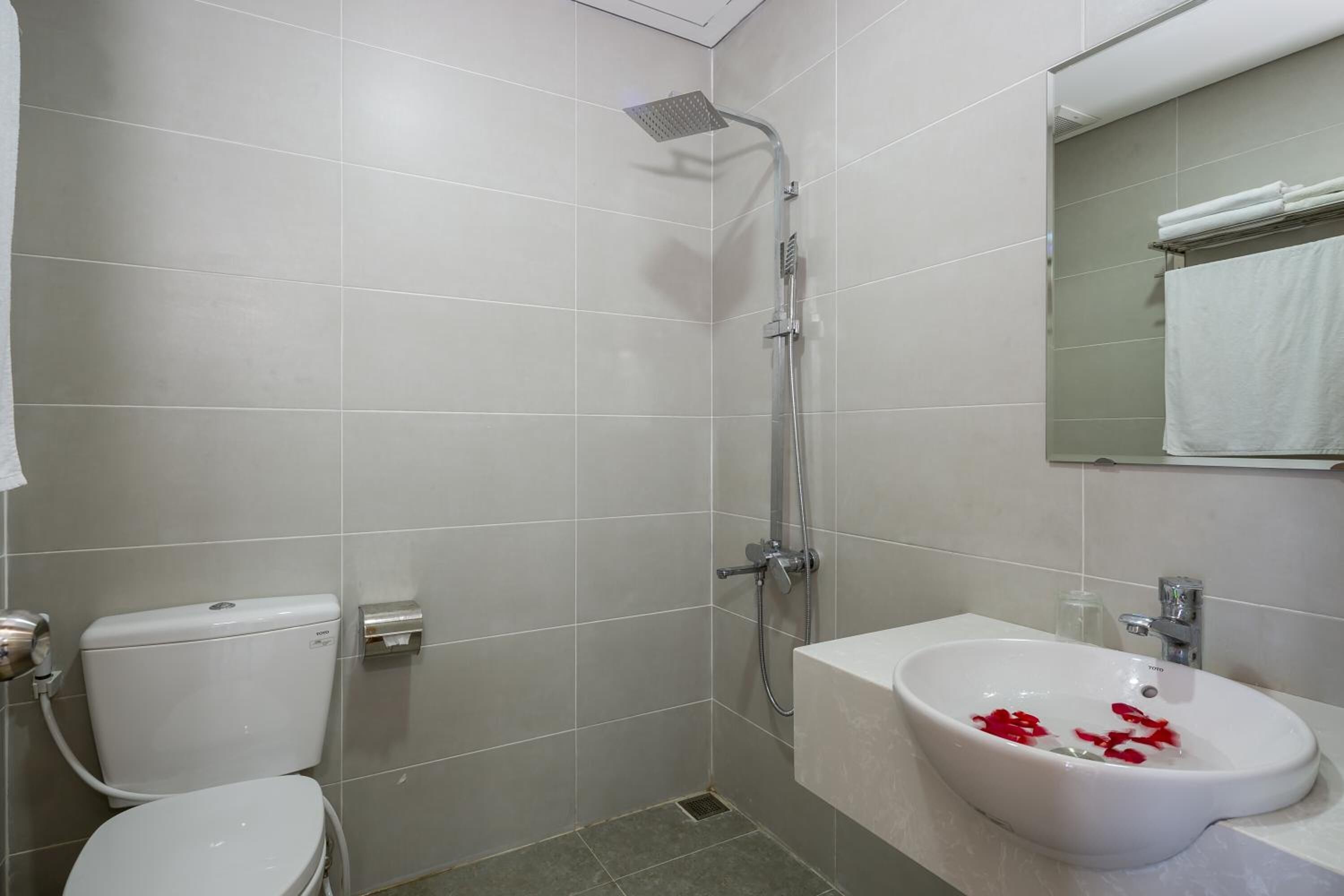 Een badkamer met toilet, douche en wastafel.