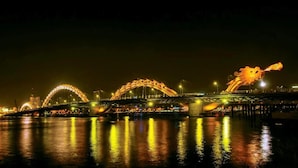 A brightly lit bridge with arched structures and a dragon sculpture at the end. - Anh Villa Hotel (Da Nang)