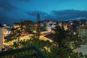 A nighttime view of a town with buildings, a bridge, and trees. - ELC Luxury Da Lat Hotel & Apartment (Xuan Huong - Da Lat)