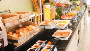 A buffet with various food items and a person in the background. - ELC Luxury Da Lat Hotel & Apartment (Xuan Huong - Da Lat)
