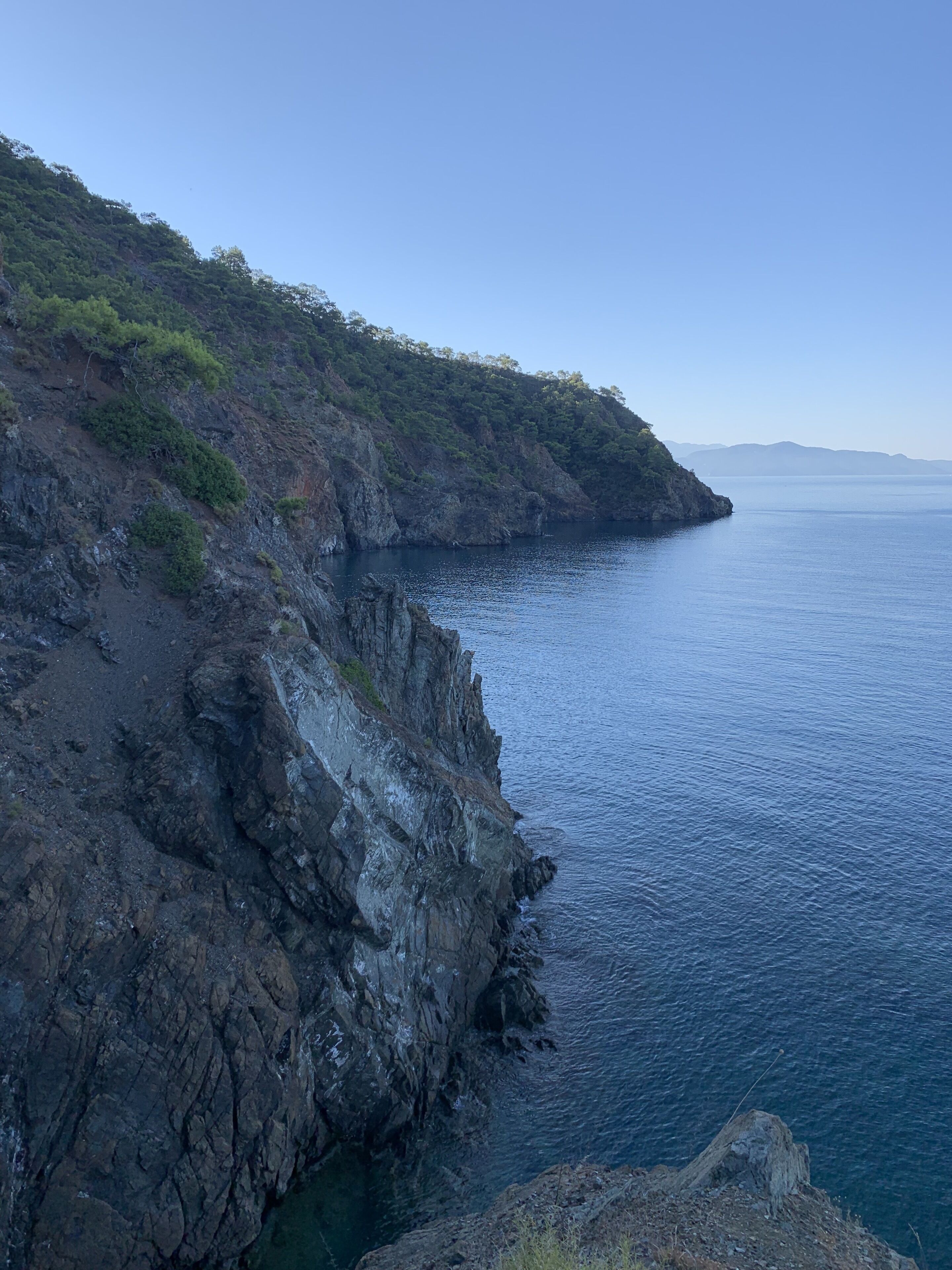 Un paisaje costero con acantilados rocosos y mar tranquilo.