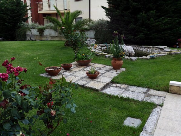 A garden with potted plants arranged on a stone pathway. - I Gelsomini (Melfi)
