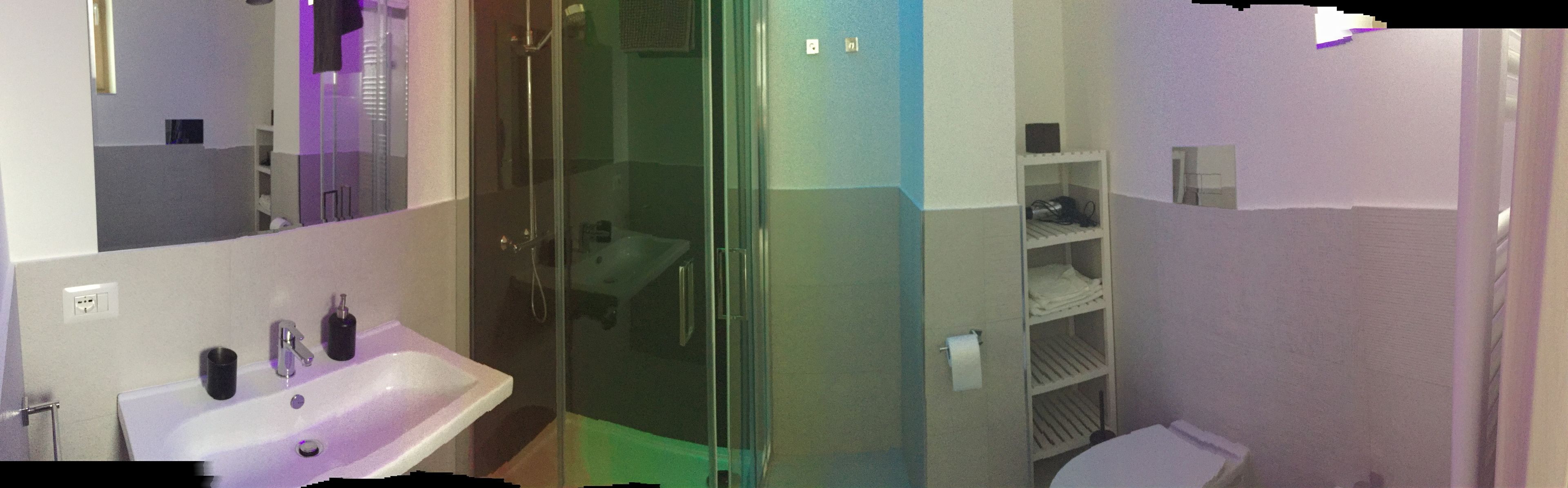 Un baño con cabina de ducha de vidrio, lavabo e inodoro.