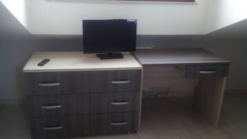 Un espace de travail compact comprenant un bureau et un téléviseur, avec une fenêtre située juste au-dessus.