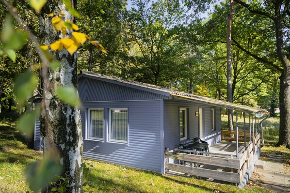 A small, single-story cabin with a porch and a covered outdoor seating area. - Bad Sonnenland (Moritzburg)