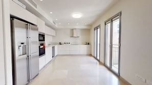 A modern kitchen with built-in appliances, a central island, and large windows. - Rental Israel - Mamilla Residences (Jerusalem)