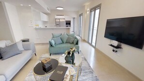 A modern living room with a sofa, a coffee table, and a TV. - Rental Israel - Mamilla Residences (Jerusalem)