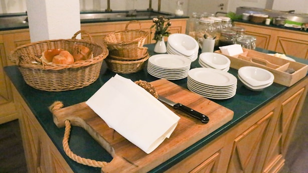 Un buffet composé de paniers, d’assiettes et d’une planche à découper.