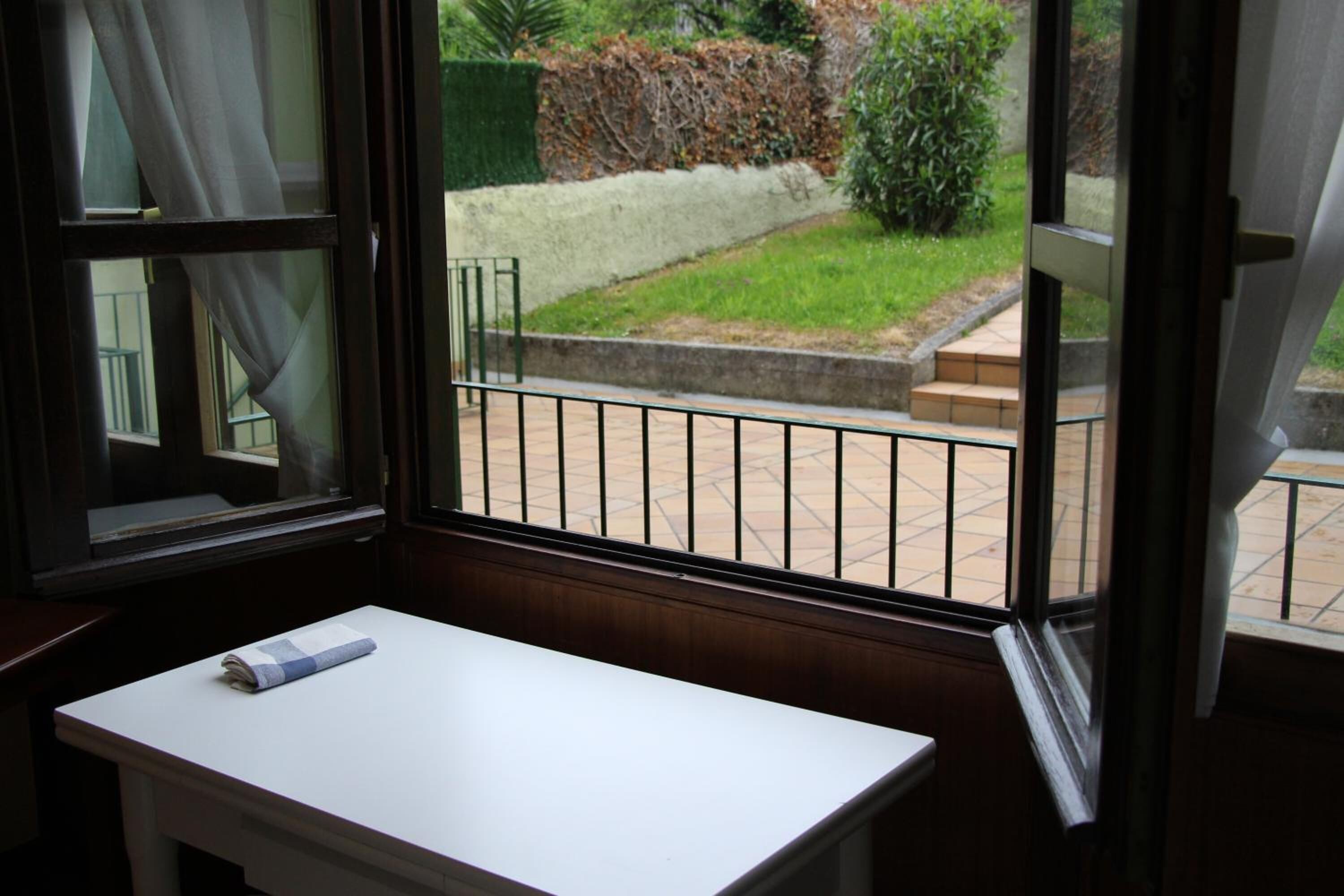 A room with a window overlooking a garden.