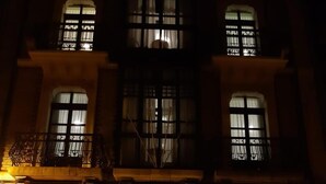 Un edificio con tres entradas en arco, cada una con un letrero encima.