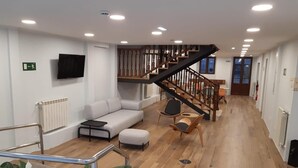 Un interior moderno con una escalera, un sofá y una mesa de centro.