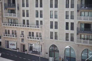 A multi-story building with balconies, large windows, and a storefront with a colorful display.