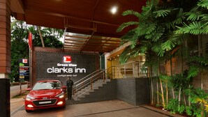 A red car parked in front of a hotel entrance with a sign reading "Green View Clark's Inn".
