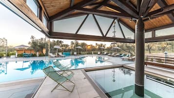 Piscine couverte, piscine extérieure, parasols de plage, chaises longues