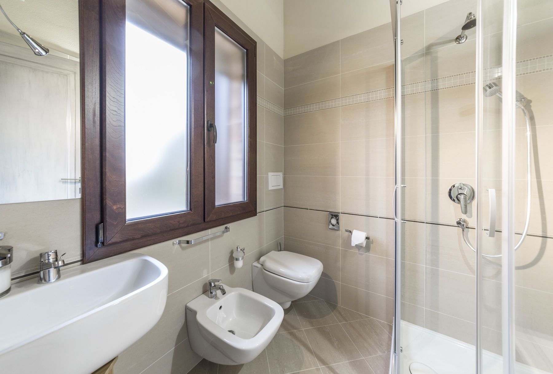A bathroom with a bathtub, a bidet, a toilet, and a shower enclosure.