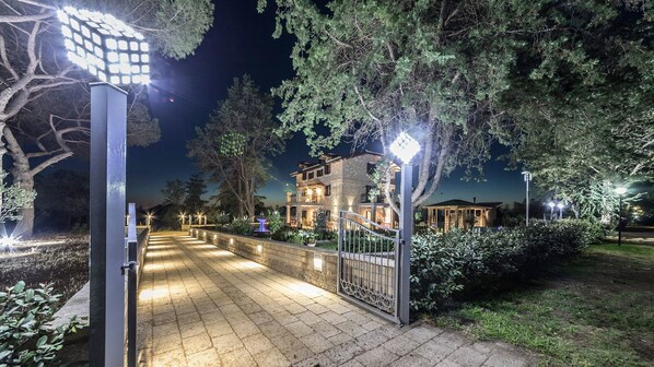 A gated entrance to a property with a stone pathway leading to a multi-story building.