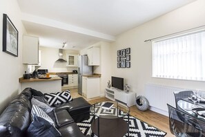 Apartamento luxo, várias camas, para não fumantes | Sala de estar | TV de tela plana
