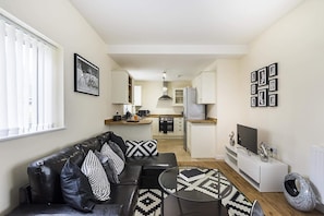 Apartamento luxo, várias camas, para não fumantes | Sala de estar | TV de tela plana