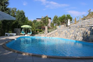 季节性开放的室外游泳池，池畔遮阳伞，日光浴躺椅